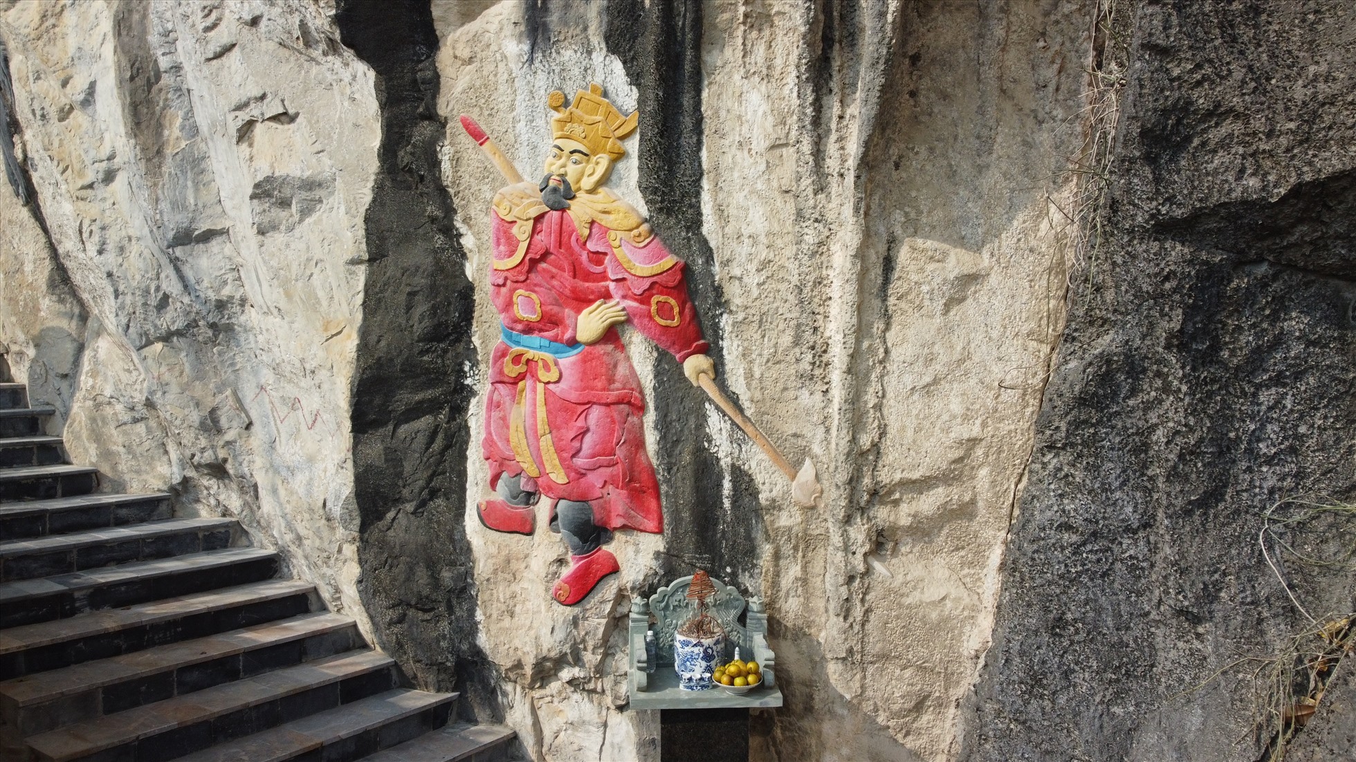 Hình tượng người trên vách đá được dùng sơn đỏ, vàng để tô lên. Ảnh: Q.D