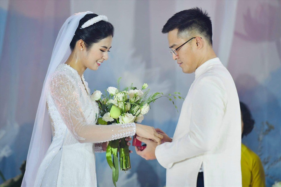 Ngọc Hân diện áo dài trắng, hạnh phúc trong giây phút trao nhẫn cưới với chồng. Ảnh: Nhân vật cung cấp