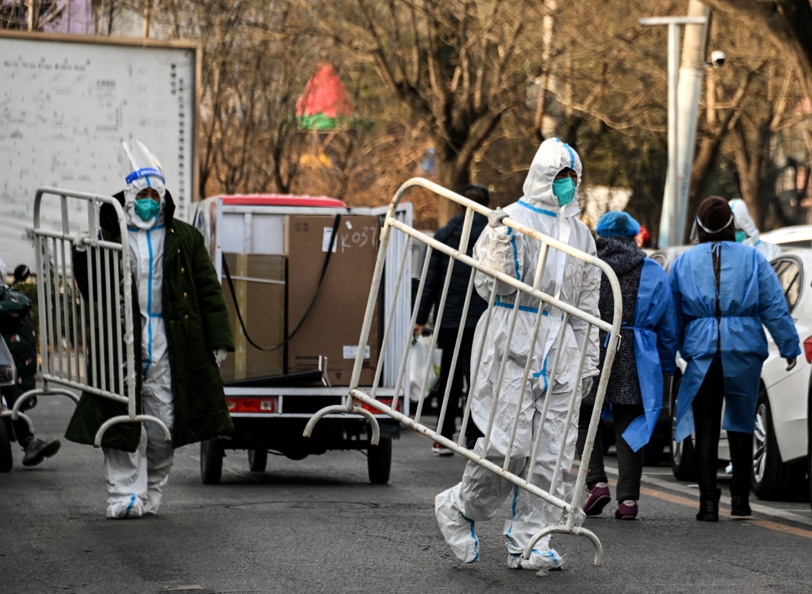 Nhân viên y tế mang theo rào chắn trong một khu dân cư vừa mở cửa sau đợt phong tỏa COVID-19 ở Bắc Kinh tháng 12.2022. Ảnh: AFP