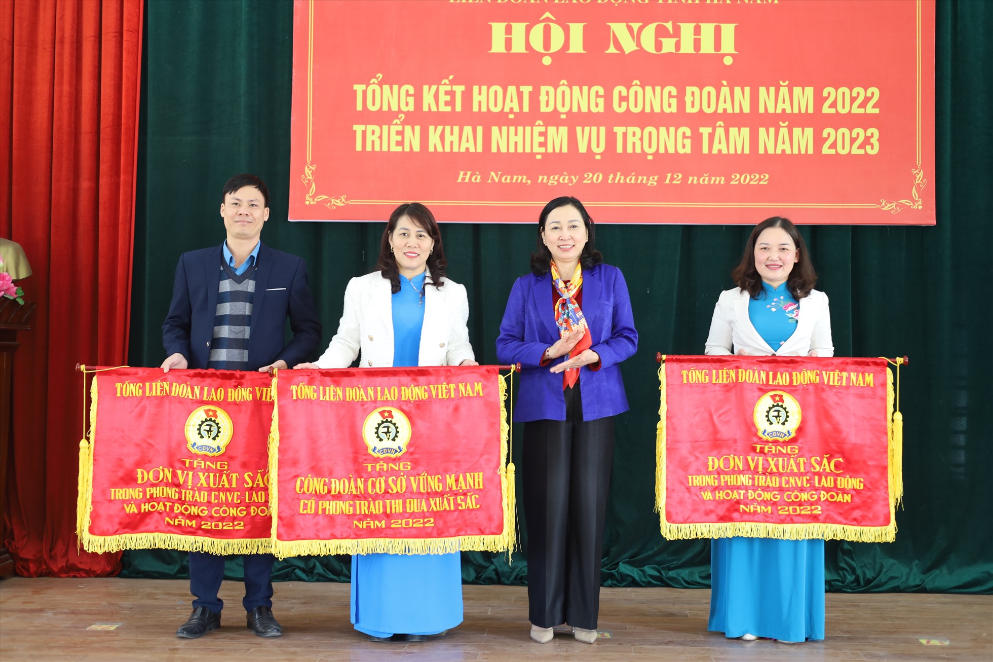 Bà Đinh Thị Lụa - Phó Bí thư Thường trực tỉnh ủy Hà Nam tặng Cờ thi đua của Tổng Liên đoàn Lao động Việt Nam cho các đơn vị xuất sắc. Ảnh: Hoàng Hải