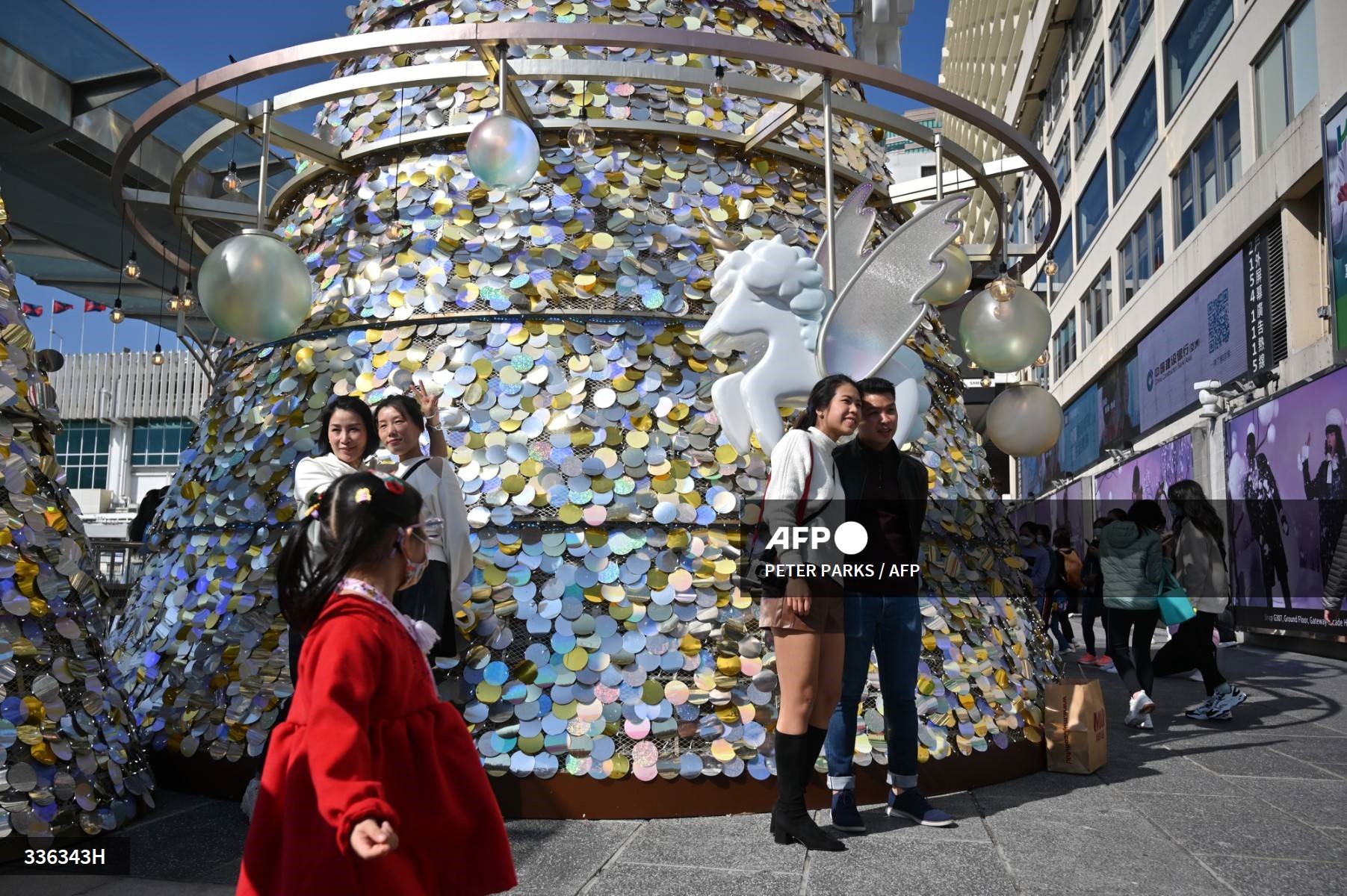 Du khách chụp ảnh bên cạnh trang trí Giáng sinh ở Hong Kong (Trung Quốc) ngày 24.12.2022. Ảnh: AFP