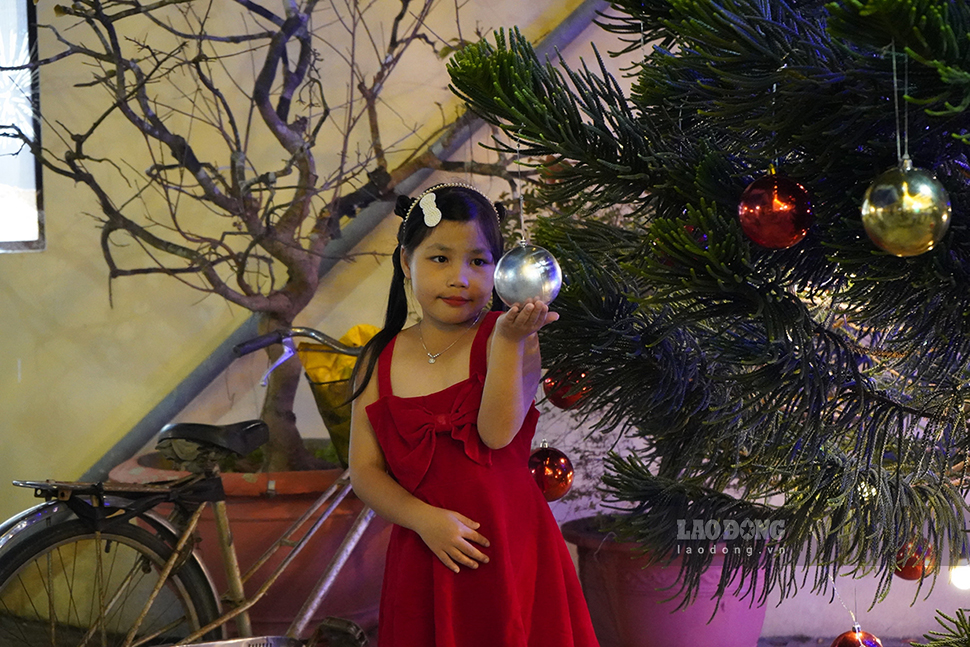 Các em nhỏ chụp hình với cây thông Noel.