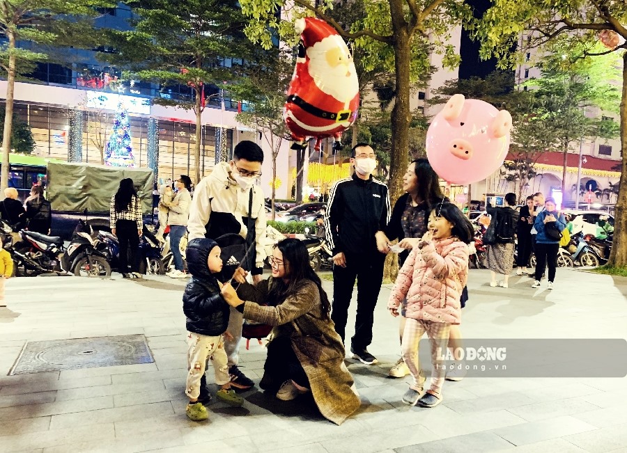Nhiều gia đình dẫn con nhỏ đi chơi Noel, tận hưởng khoảnh khắc vui vẻ đầm ấm.