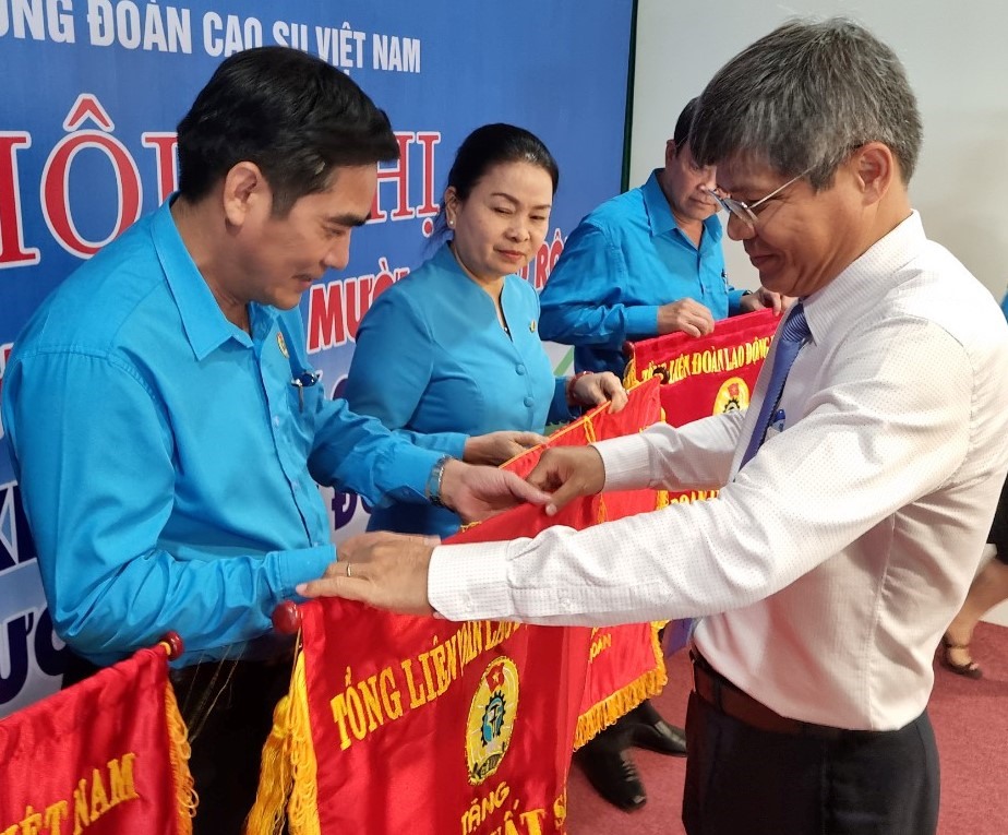 Ông Trần Công Kha - Bí thư Đảng ủy, Chủ tịch HĐQT VRG (bên phải) - tặng cờ thi đua của Tổng LĐLĐ Việt Nam cho các đơn vị có thành tích xuất sắc của Công đoàn Caosu Việt Nam. Ảnh: Nam Dương