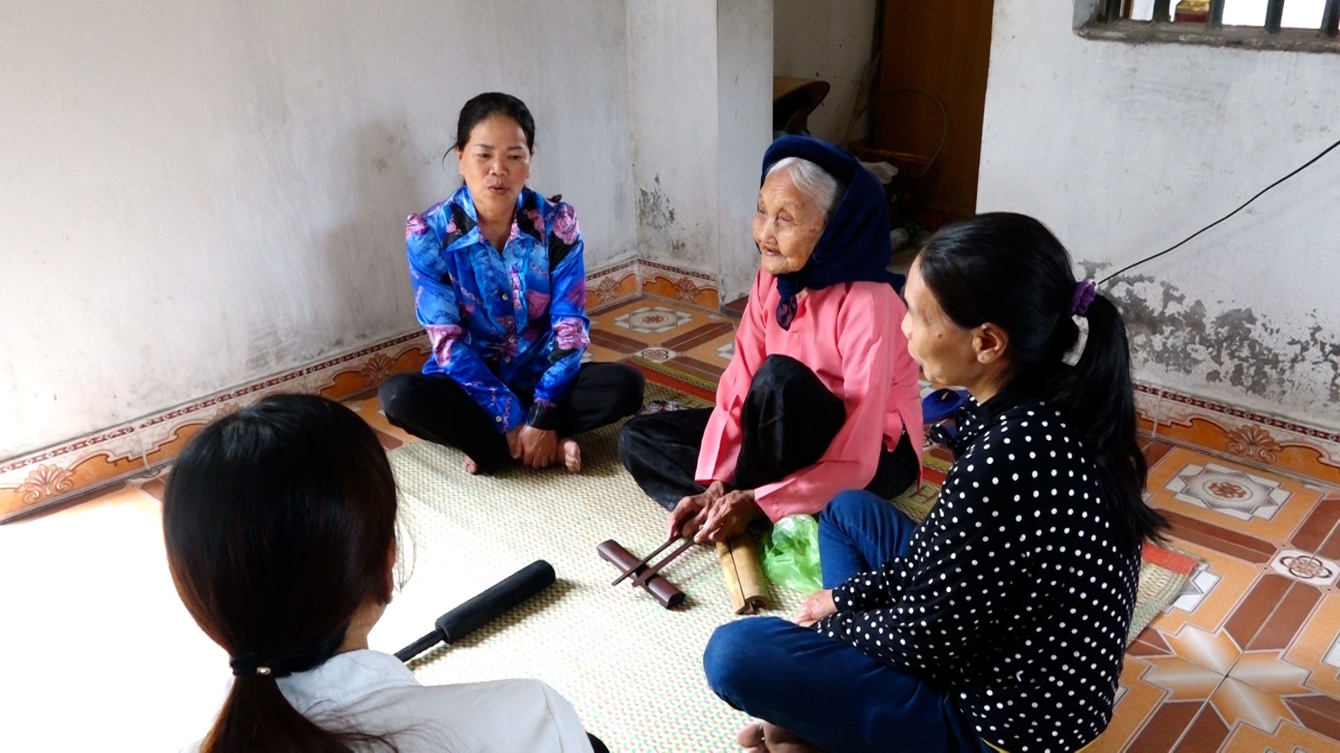 Nghệ nhân nhân dân Đặng Thị Tự truyền dạy cho thế hệ trẻ về hát nhà tơ. Ảnh: Phòng VHTT huyện Đầm Hà