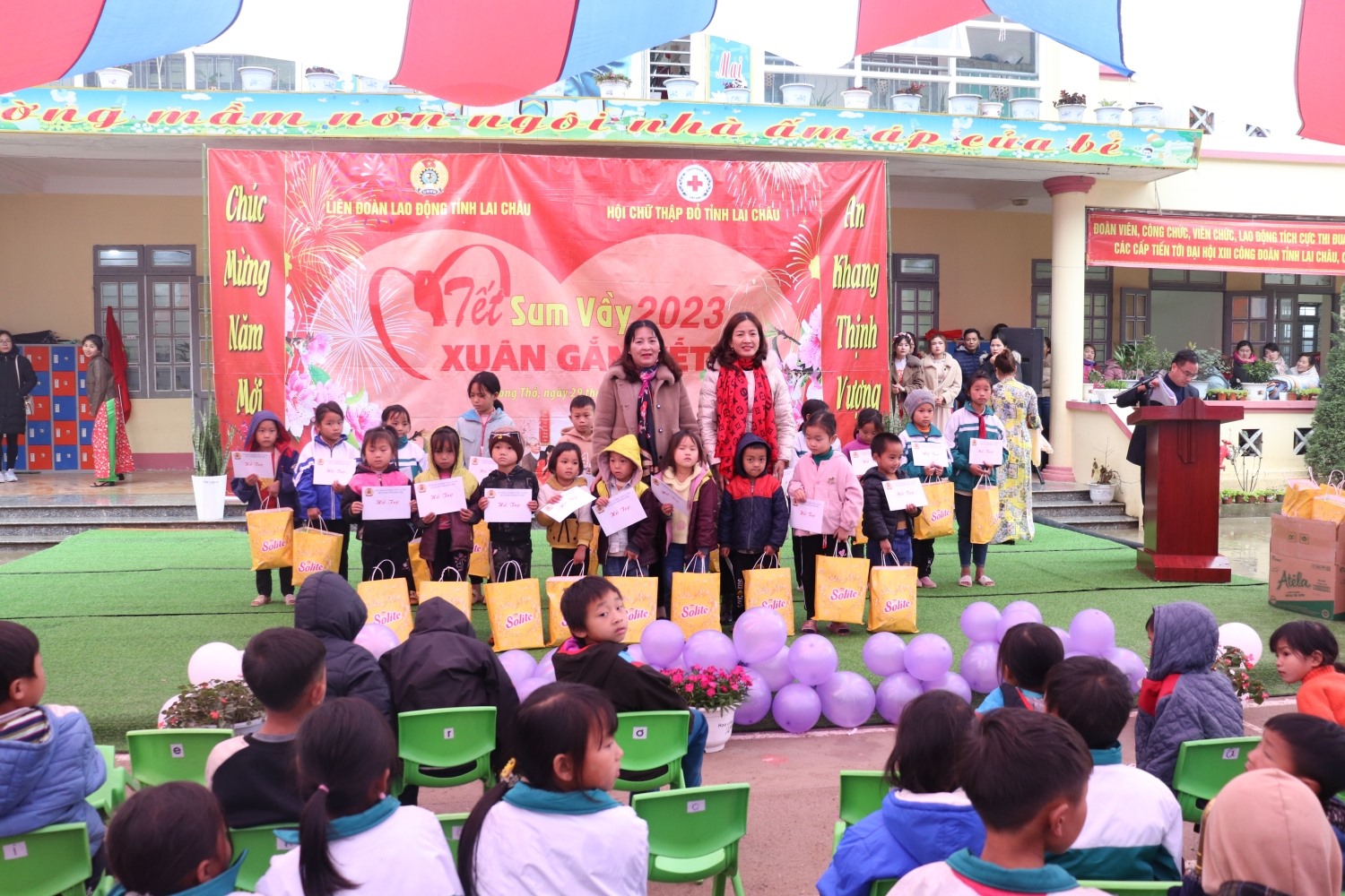 Lãnh đạo LĐLĐ tỉnh Lai Châu và UBND huyện Phong Thổ tặng quà cho các cháu học sinh có hoàn cảnh khó khăn. Ảnh: Xuân Nghĩa.