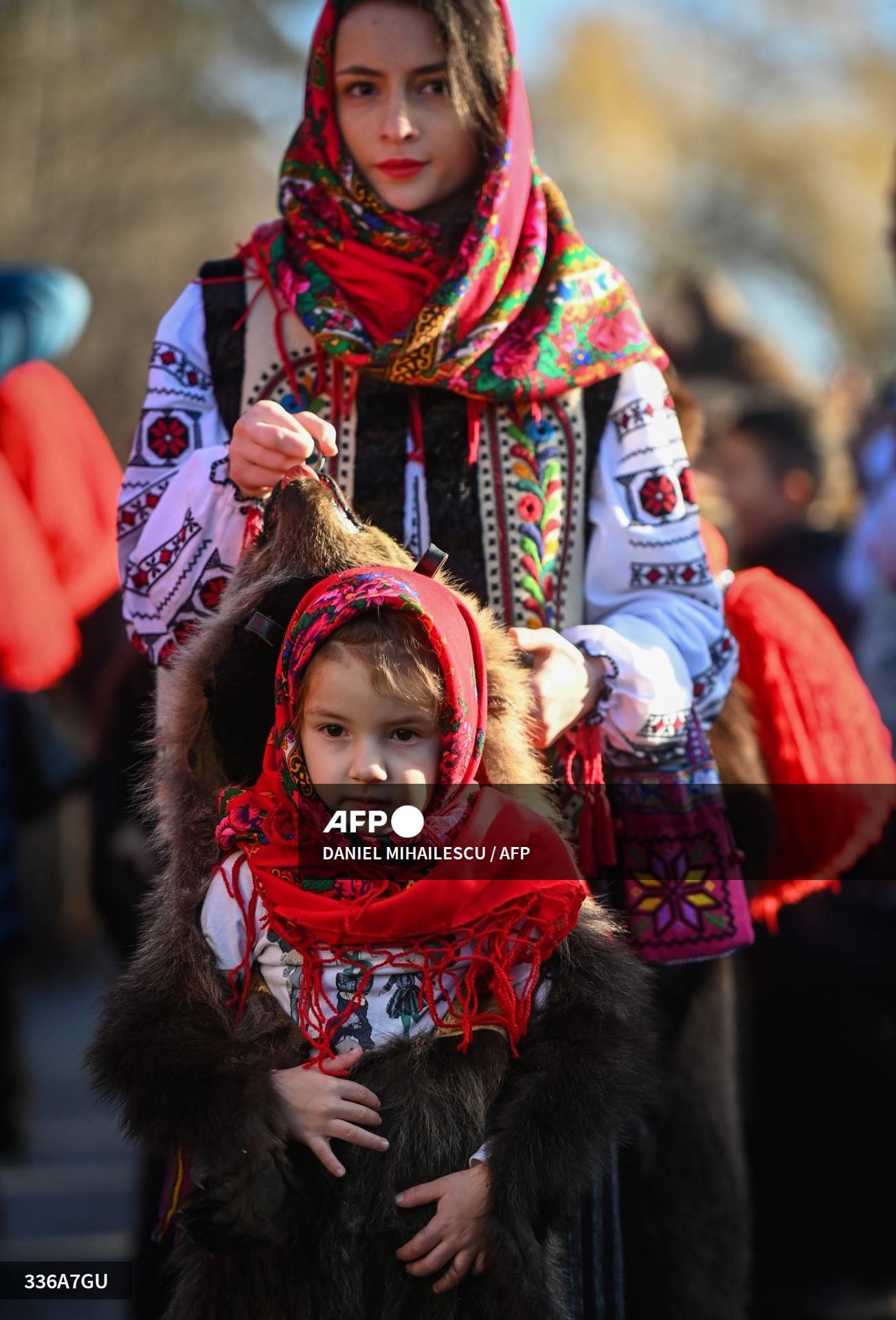 Một người phụ nữ và em bé mặc trang phục da gấu tham dự cuộc diễu hành Bearskin Parade ở Comanesti, Romania ngày 30.12. Ảnh: AFP