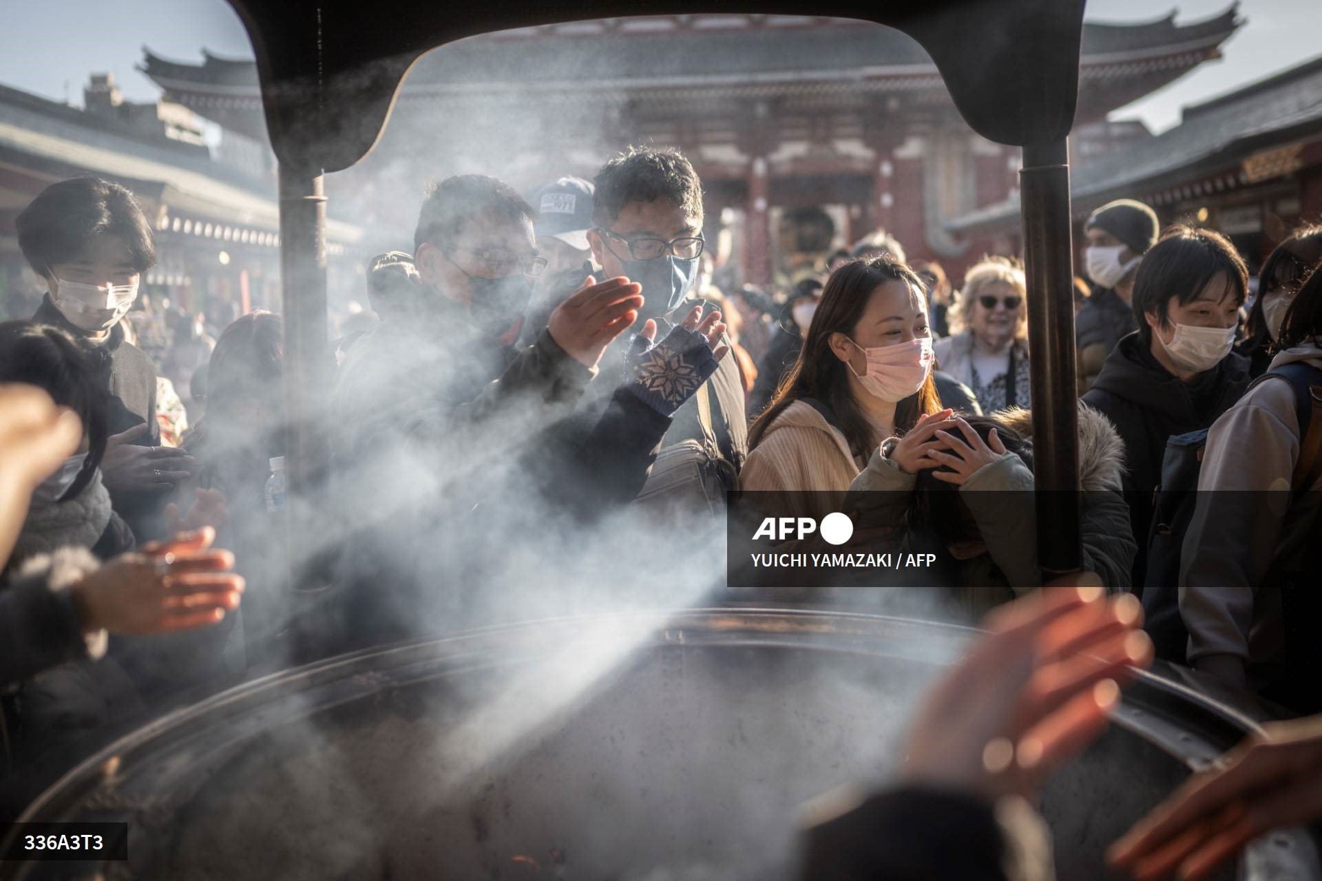 Mọi người cầu nguyện quanh một lư hương tại chùa Sensoji trước kỳ nghỉ năm mới ở Tokyo, Nhật Bản. Ảnh: AFP