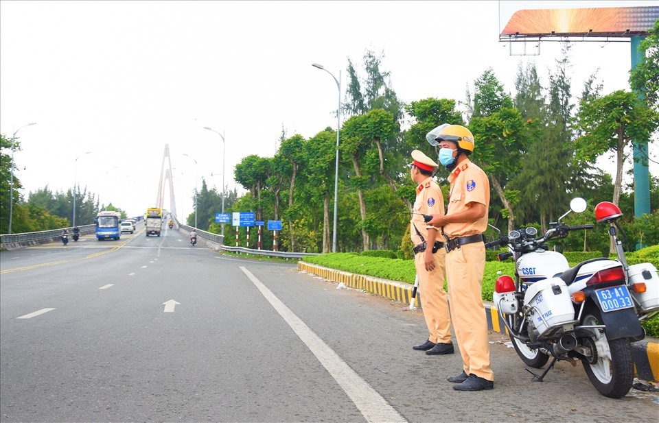 Lực lượng chức năng của Tiền Giang và Bến Tre phối hợp điều tiết giao thông tại điểm nóng ùn tắc giao thông ở cầu Rạch Miều. Ảnh: Thành Nhân