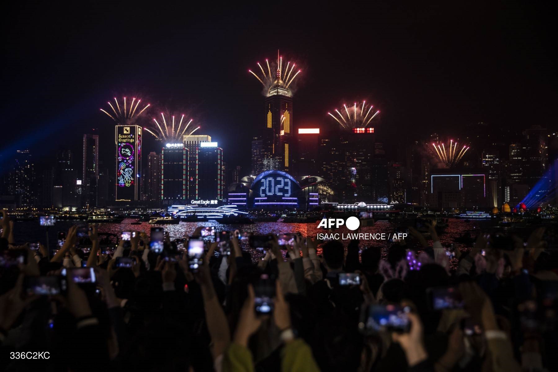 Mọi người theo dõi màn trình diễn pháo hoa và laser mừng năm mới ở cảng Victoria ở Hong Kong (Trung Quốc) ngày 1.1.2023. Ảnh: AFP
