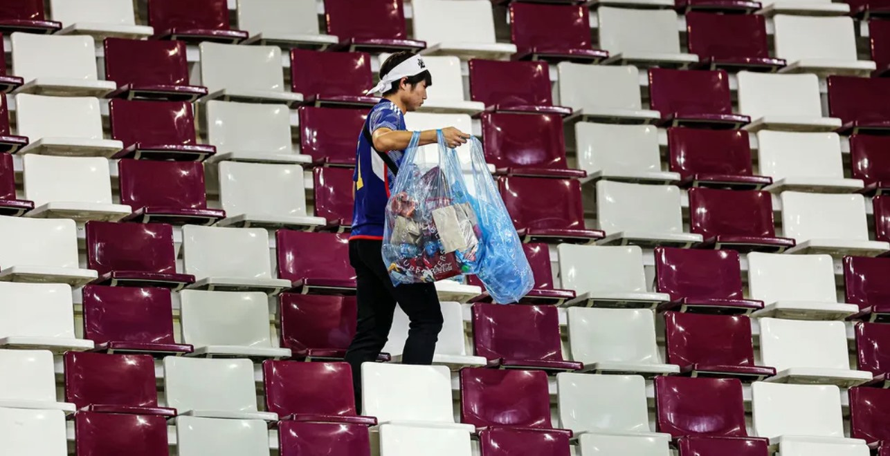 Cổ động viên Nhật Bản ở lại sân vận động Khalifa rất lâu sau tiếng còi mãn cuộc của trận thắng Đức 2-1 để nhặt rác. Ảnh chụp màn hình