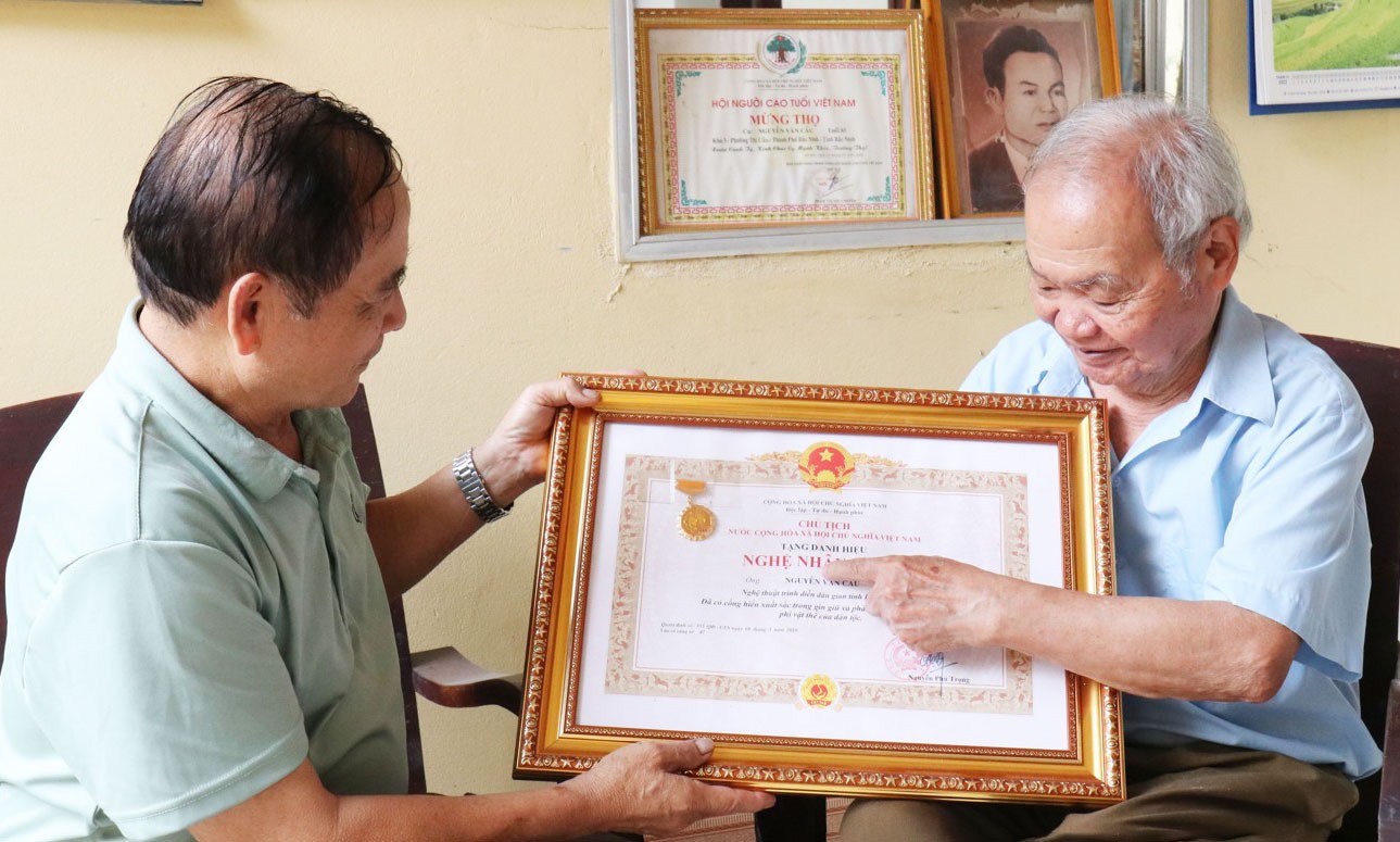 Nghệ nhân Nhân dân Nguyễn Văn Cầu (bên phải) tự hào về Bằng công nhận Nghệ nhân Ưu tú do Chủ tịch nước công nhận.