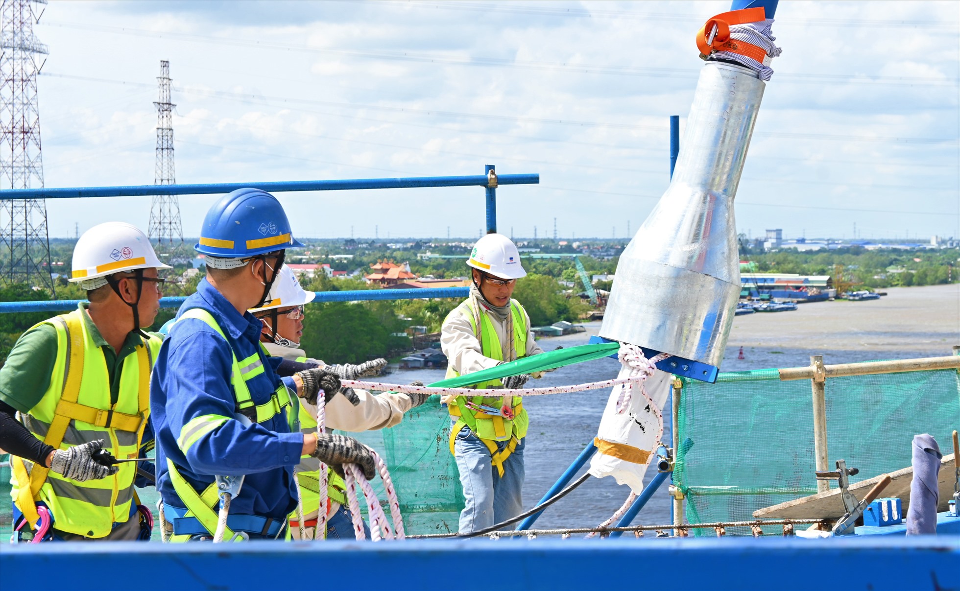 Công nhân thi công căng dây cáp đầu tiên tại tháp trụ T16 dự án công trình cầu Mỹ Thuận 2. Ảnh: Thành Nhân.