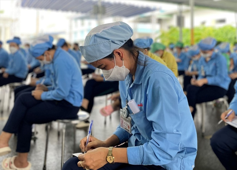 Công nhân, người lao động chăm chú ghi chép trong buổi tuyên truyền. Ảnh: Nguyễn Phú Duy