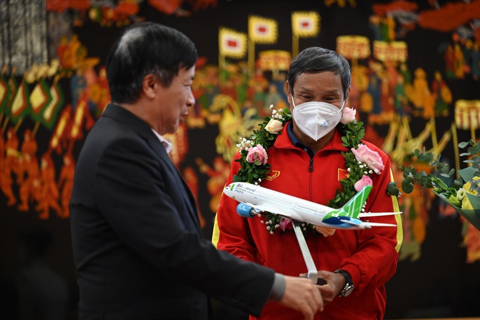 Đại diện lãnh đạo Bamboo Airways tặng hoa và lưu niệm cho huấn luyện viên Mai Đức Chung và đội tuyển nữ Việt Nam. Huấn luyện viên 71 tuổi chia sẻ: “Bây giờ, khi trở về quê hương, chúng tôi mới cảm thấy không khí Năm mới“. Ảnh: Quang Thắng