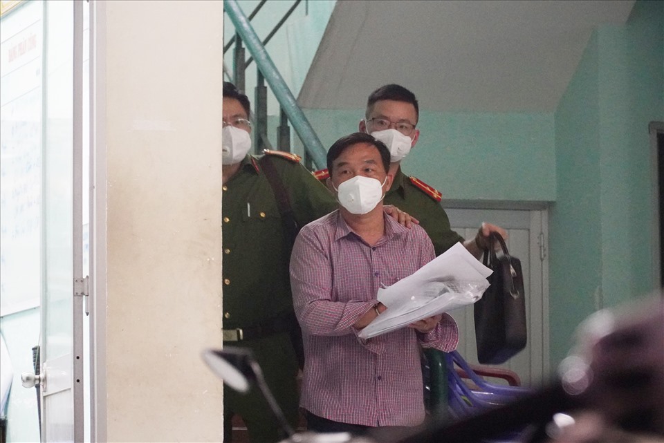 Ông Lê Nguyễn Thanh Danh, nguyên Phó Giám đốc Sở TNMT tỉnh Bình Thuận bị còng tay di lý lên xe. Ảnh: DT