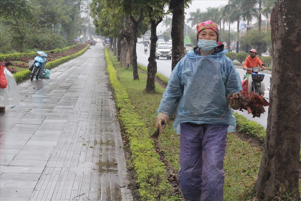 Chiếc áo mưa mỏng tang giúp công nhân cây xanh che được cơn mưa nhỏ và phần nào giảm được cái lạnh “cắt da“.