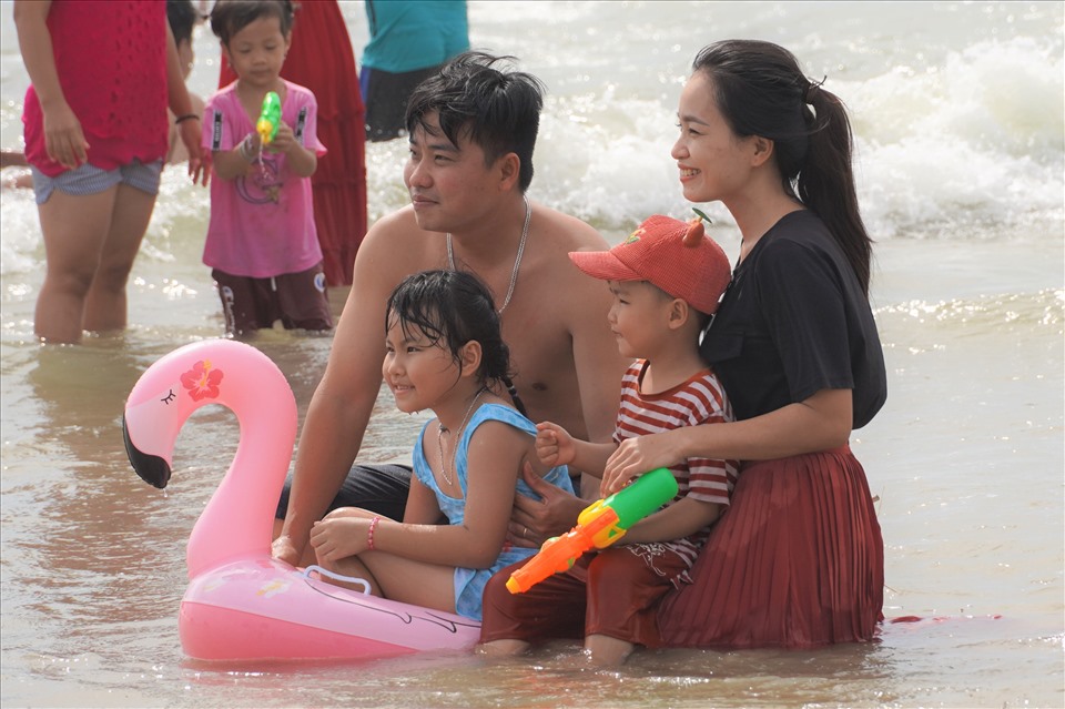 Một gia đình “tiêu chuẩn” vui vẻ tạo dáng trong sóng nước. Ảnh: T.A