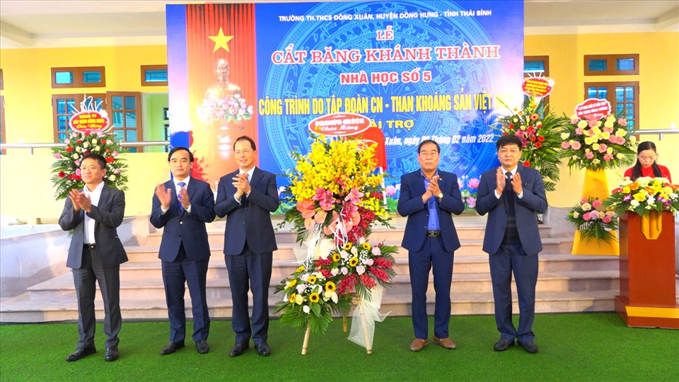 Lãnh đạo Tập đoàn tặng hoa chúc mừng lãnh đạo trường tiểu học và THCS Đông Xuân. Ảnh: TKV