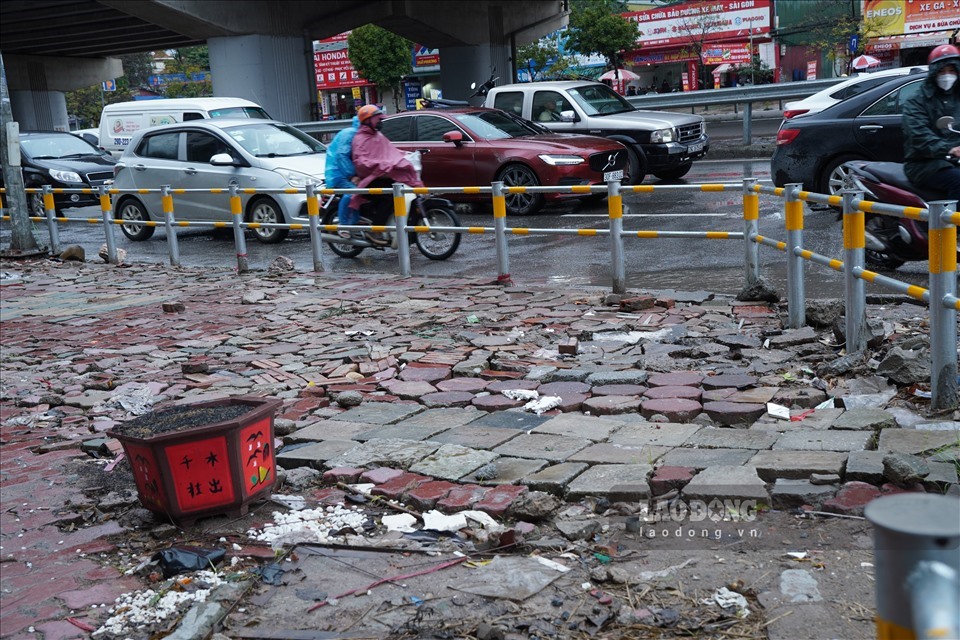 Nhiều vật tư xây dựng xếp đặt một góc bên trong rào chắn vỉa hè, gây mất mỹ quan đô thị, ảnh hưởng người đi bộ. Ảnh: PV.