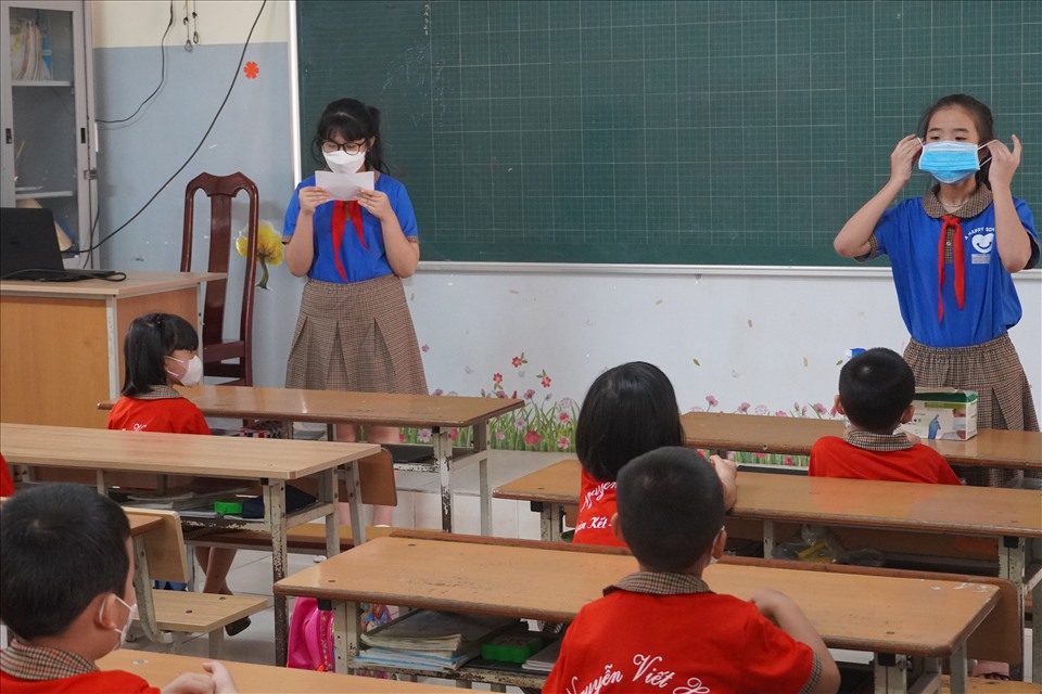 Ở trường Tiểu học Nguyễn Viết Xuân, các em lớp 5 còn giúp hướng dẫn, minh họa cho các em nhỏ hơn về các thao tác đeo khẩu trang đúng cách, rửa tay sát khuẩn khi đến trường. Ảnh: T.A