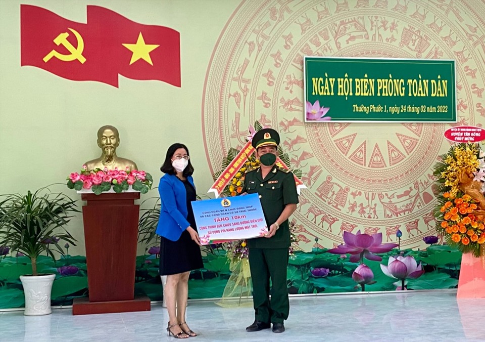 Đồng chí Trần Thanh Vân, Phó Chủ tịch Công đoàn Viên chức tỉnh Đồng Tháp (trái) trao bảng tượng trưng 10km công trình đèn chiếu sáng đường biên giới sử dụng pin năng lượng mặt trời.