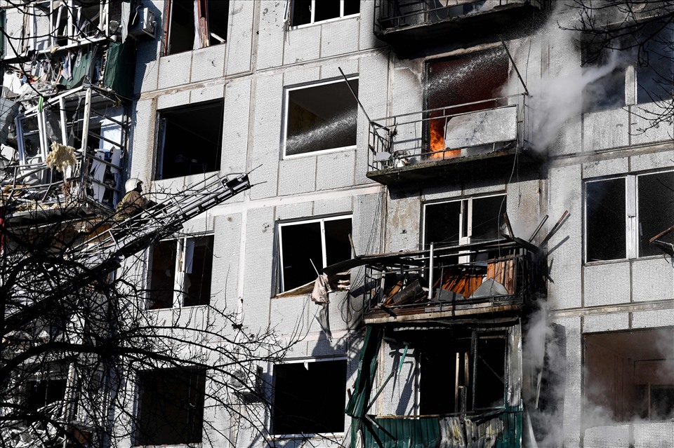 Đám cháy một tòa nhà sau vụ đánh bom ở thị trấn Chuguev, miền đông Ukraina ngày 24.2. Ảnh: AFP