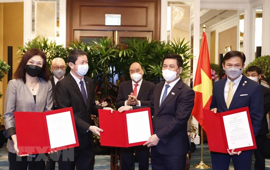 Chủ tịch nước Nguyễn Xuân Phúc chứng kiến việc trao giấy phép đầu tư vào Việt Nam cho các doanh nghiệp Singapore. Ảnh: TTXVN