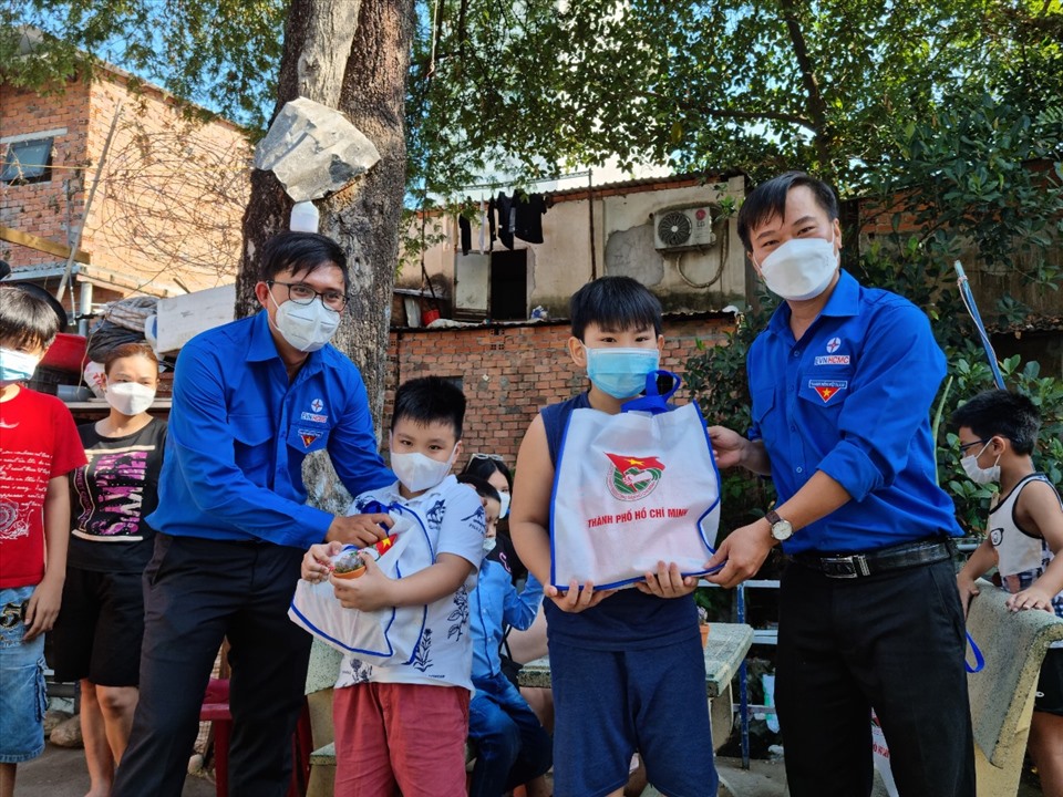 Thanh niên công nhân Tổng Công ty Điện lực TPHCM tặng quà cho trẻ em khu xóm trọ Phường 15, quận Tân Bình. Ảnh: Nam Dương