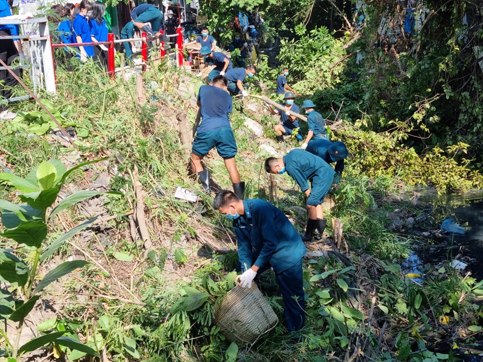 Thanh niên quân đội phát quang cây hoang, khơi thông dòng chảy cho kênh Tân Trụ. Ảnh: Nam Dương