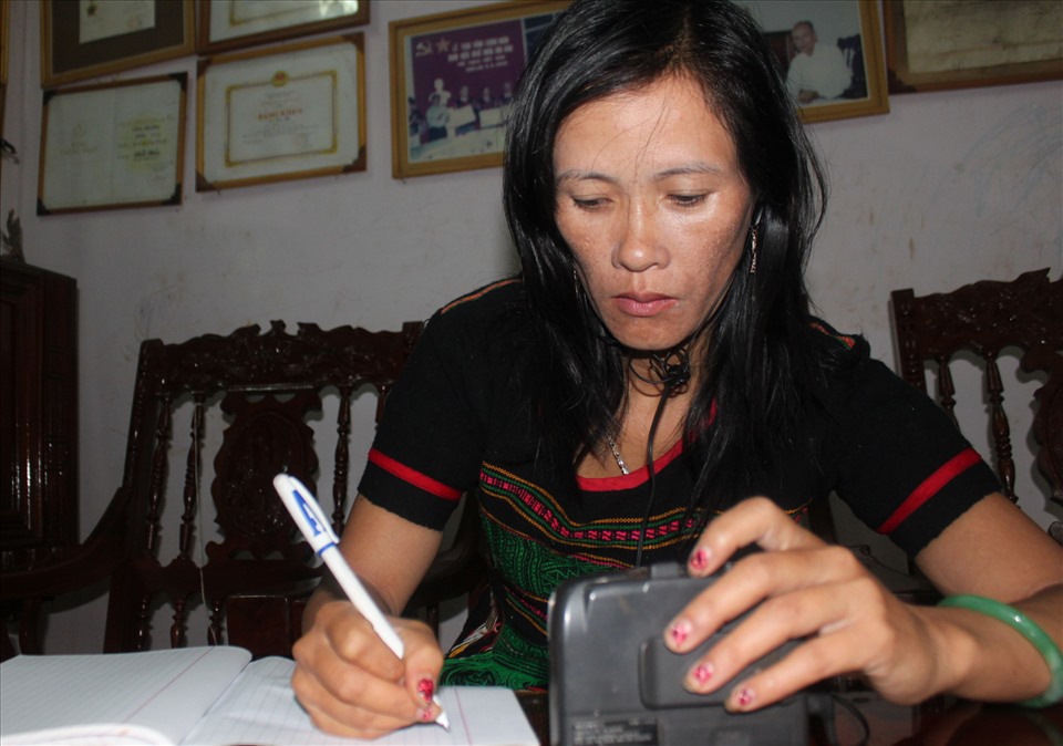 Nghệ nhân Thị Mai say sưa chép sử thi của dân tộc thành tiếng M'Nông và tiếng Việt. Ảnh: Đức Hùng