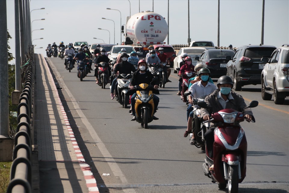 Sáng ngày mùng 5 Tết, hàng chục ngàn người sử dụng xe máy nối nhau qua cầu Phú Cường từ Thành phố Hồ Chí Minh vào Bình Dương để trở lại với công việc.