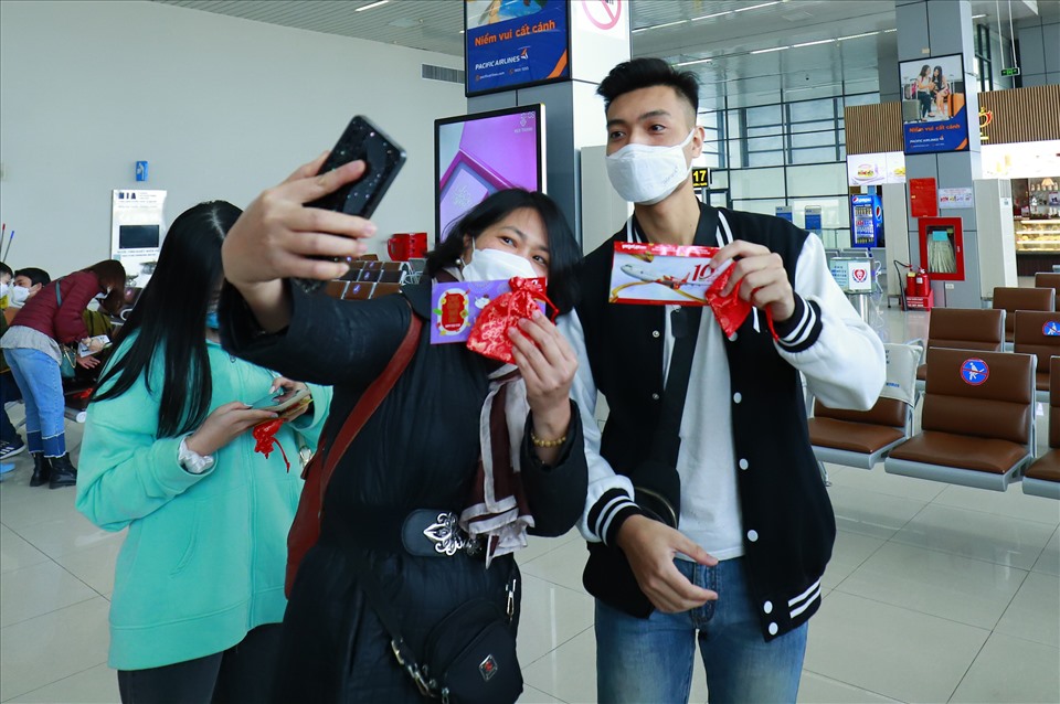 Hai hành khách chụp ảnh với quà mừng tuổi của Vietjet trong ngày đầu năm mới tại sân bay Nội Bài. Ảnh: Đức Minh