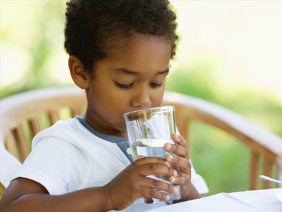 Hãy khuyến khích trẻ uống nhiều nước mỗi ngày. Ảnh: Xinhua