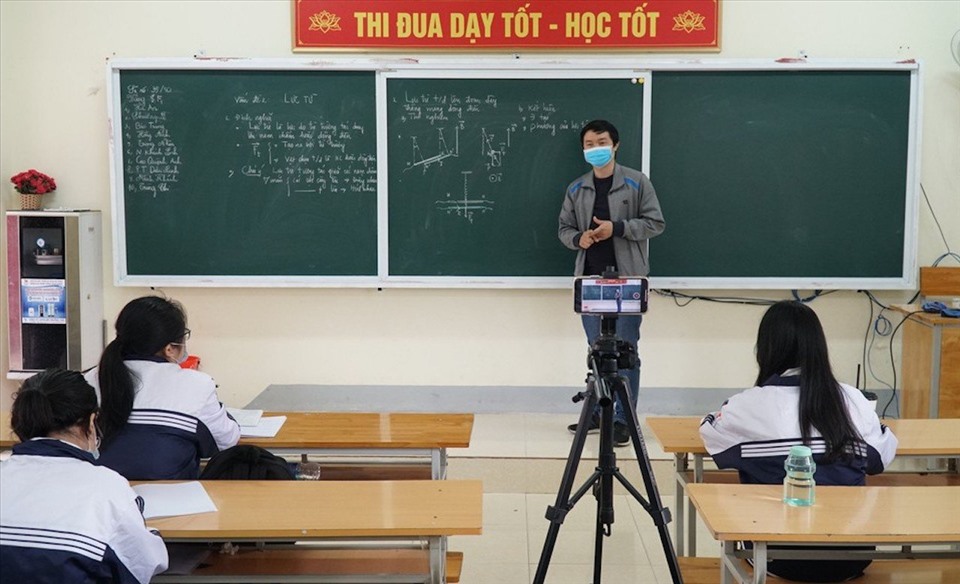 Giáo viên tại Hà Nội cùng lúc đảm đương 2 vai: dạy trực tiếp và dạy trực tuyến đối với học sinh F0, F1 tại nhà. Ảnh: H.C.
