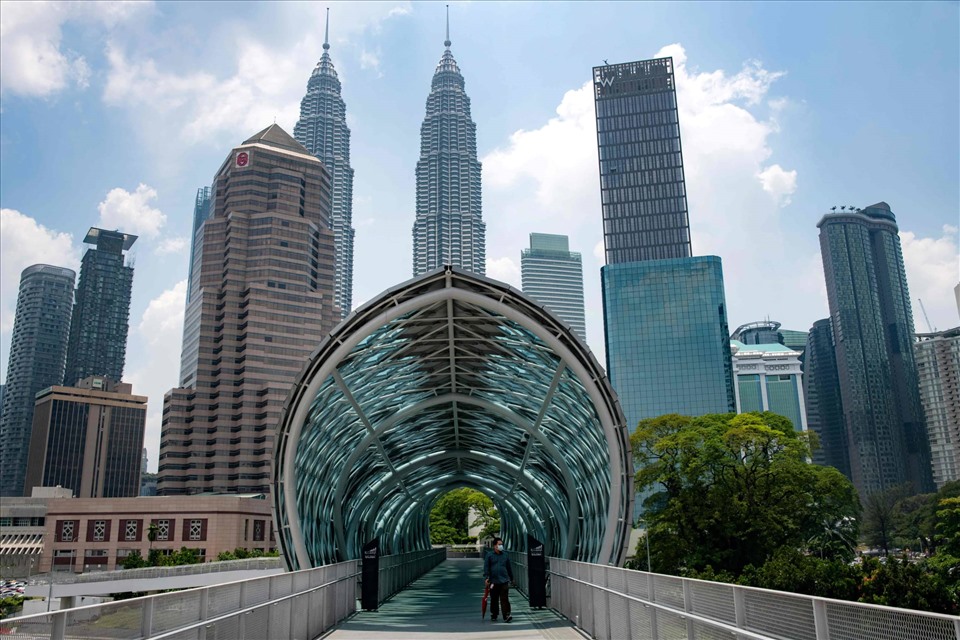 Từ 1.4, Malaysia sẽ mở cửa biên giới hoàn toàn và bắt đầu chuyển sang giai đoạn coi COVID-19 là bệnh đặc hữu. Khách quốc tế nhập cảnh chỉ cần mang theo chứng nhận PCR âm tính được thực hiện trong vòng 48 tiếng trước khi khởi hành. Họ cũng có thể sử dụng kết quả xét nghiệm nhanh trong vòng 24 giờ tính từ lúc nhập cảnh, để được phép đi khắp Malaysia. Ngoài ra, quốc gia này cũng nới lỏng một số hạn chế, quy định giãn cách xã hội nhằm góp phần đưa cuộc sống trở lại bình thường. Các nhà hàng hoạt động qua 12h đêm và bỏ giới hạn 50% công suất. Quy định đeo khẩu trang ở nơi công cộng vẫn có hiệu lực. Ảnh: AFP