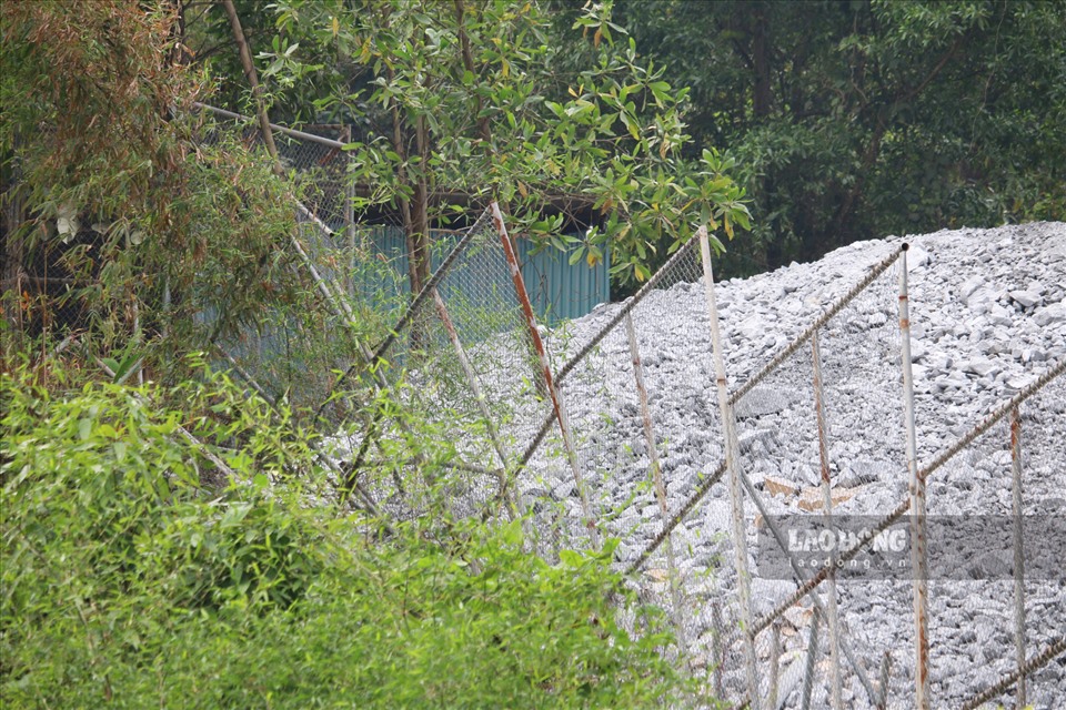 Hàng rào thép ngăn cách giữa khu vực bãi thải quặng của Công ty Tây Đô và đất của nhà bà Hoa đã bị siêu vẹo, chờ đổ sập do đất đá tảng lăn xuống.