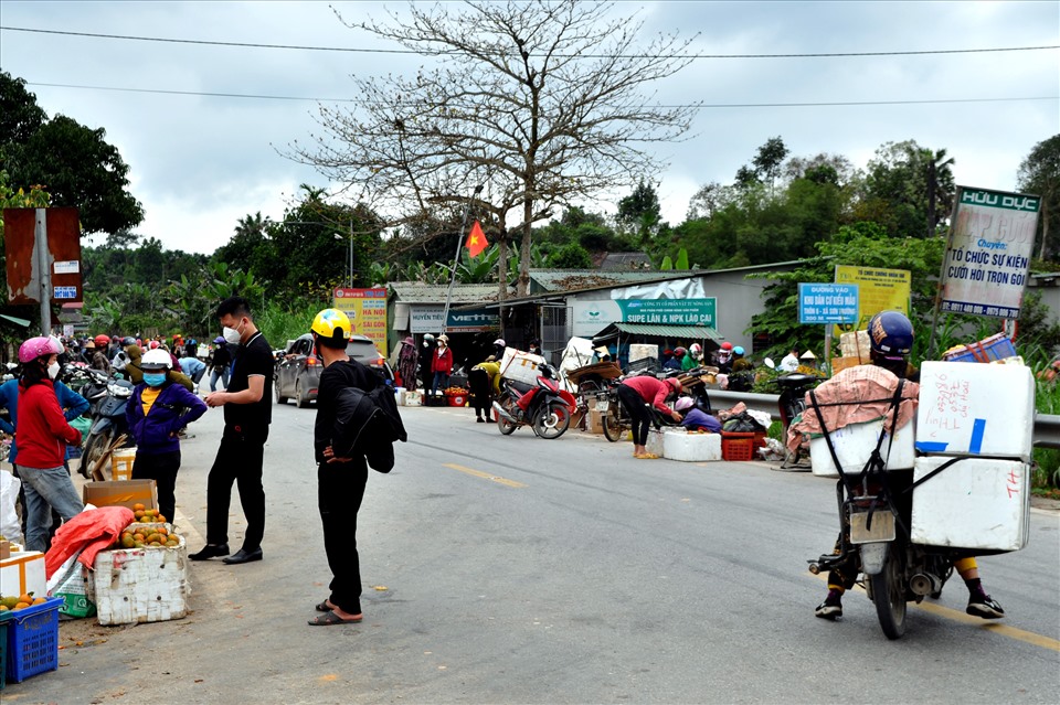 Người mua kẻ bán cam vô tư giao dịch giữa lòng đường mòn Hồ Chí Minh. Ảnh: Minh Lý