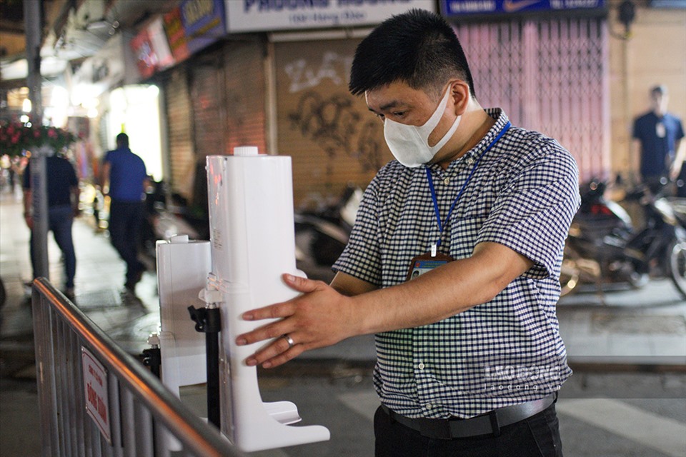 Anh Nguyễn Trung Thành (cán bộ phường Hàng Đào), kiểm tra công tác chuẩn bị phòng chống dịch COVID-19 trong ngày đầu mở cửa phố đi bộ.