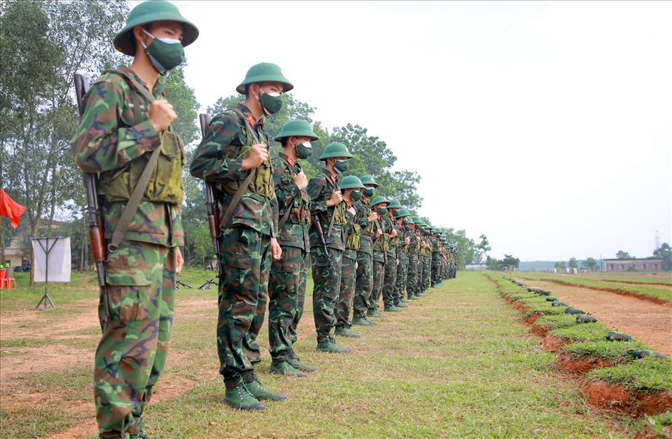 Dưới sự chỉ huy của trung đội trưởng, các chiến sĩ mới xếp thành hàng ngang trước vị trí luyện tập bắn súng.