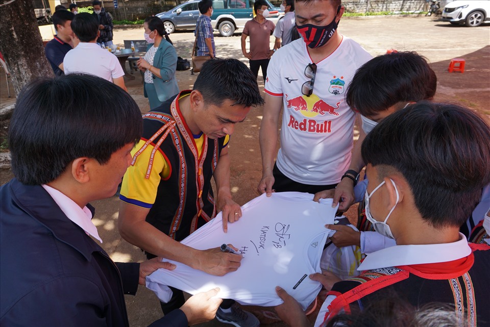 HLV trưởng CLB Hoàng Anh Gia Lai ký tặng trên áo cho các em học sinh. Ảnh T.T