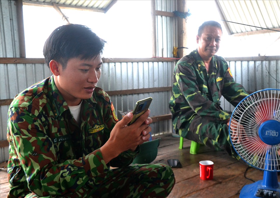Chốt trưởng trung úy Biên phòng Lê Văn Nguyên chào hỏi các đồng đội qua điện thoại thông minh. Ảnh: LT