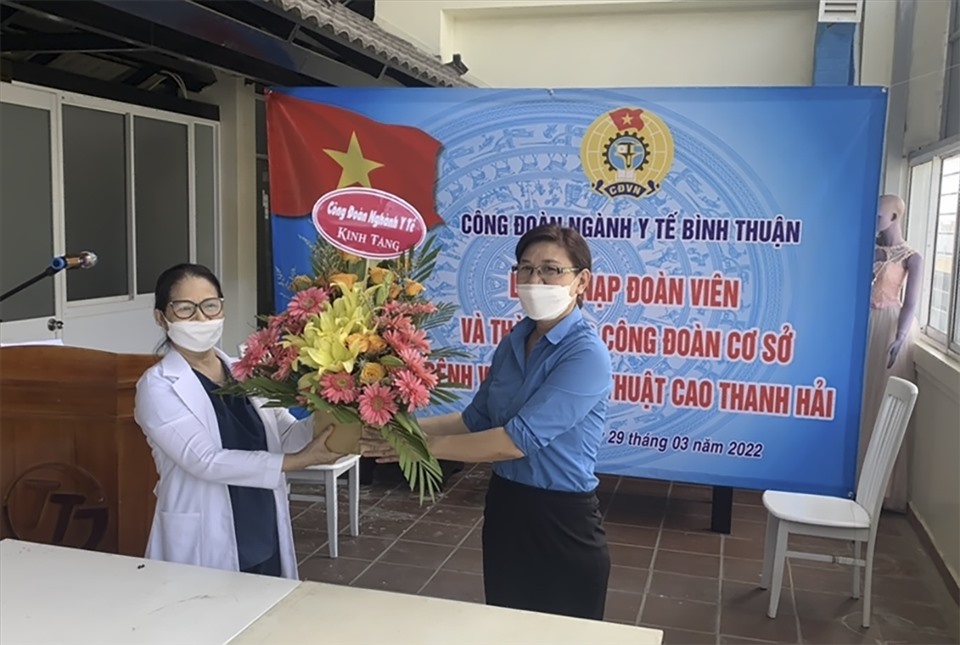 Chủ tịch Công đoàn ngành Y tế Bình Thuận trao hoa chúc mừng. Ảnh: CĐYT
