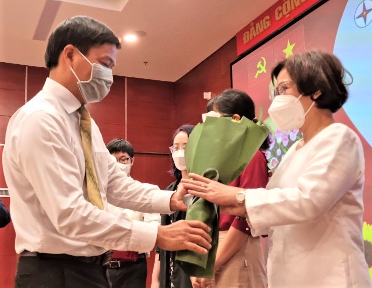 Ông Lê Văn Minh - Chủ tịch Công đoàn EVNHCMC - tặng hoa cho các bác sĩ, chuyên gia y tế tư vấn sức khỏe cho nữ CNVCLĐ của EVNHCMC sáng 7.3. Ảnh: Nam Dương