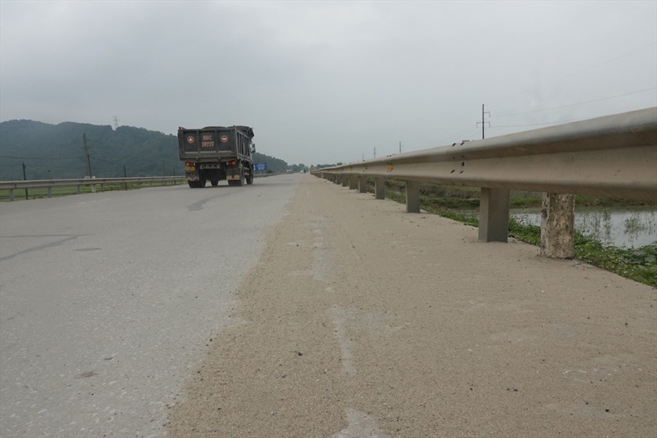 Quốc lộ 1A đoạn qua xã Xuân Lam nơi có nhiều mỏ cát vương vãi một lớp cát dày trên mặt đường. Ảnh: Trần Tuấn.