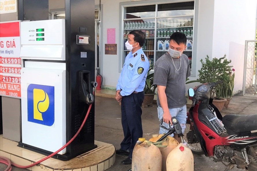 Lực lượng chức năng kiểm tra lập biên bản vi phạm hành chính đối với cửa hàng xăng dầu Trang Phước Lộc. Ảnh: Khánh Phúc