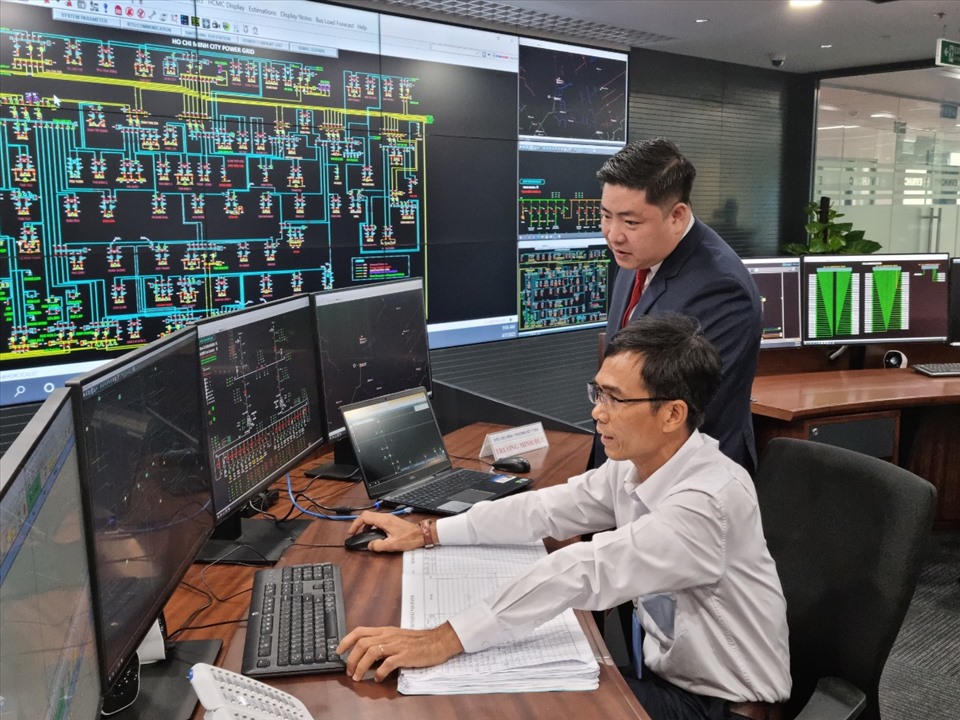 Ông Luân Quốc Hưng (người đúng) - Phó Tổng giám đốc EVNHCMC - kiểm tra hoạt động của Trung tâm điều độ hệ thống lưới điện TPHCM. Ảnh: Nam Dương