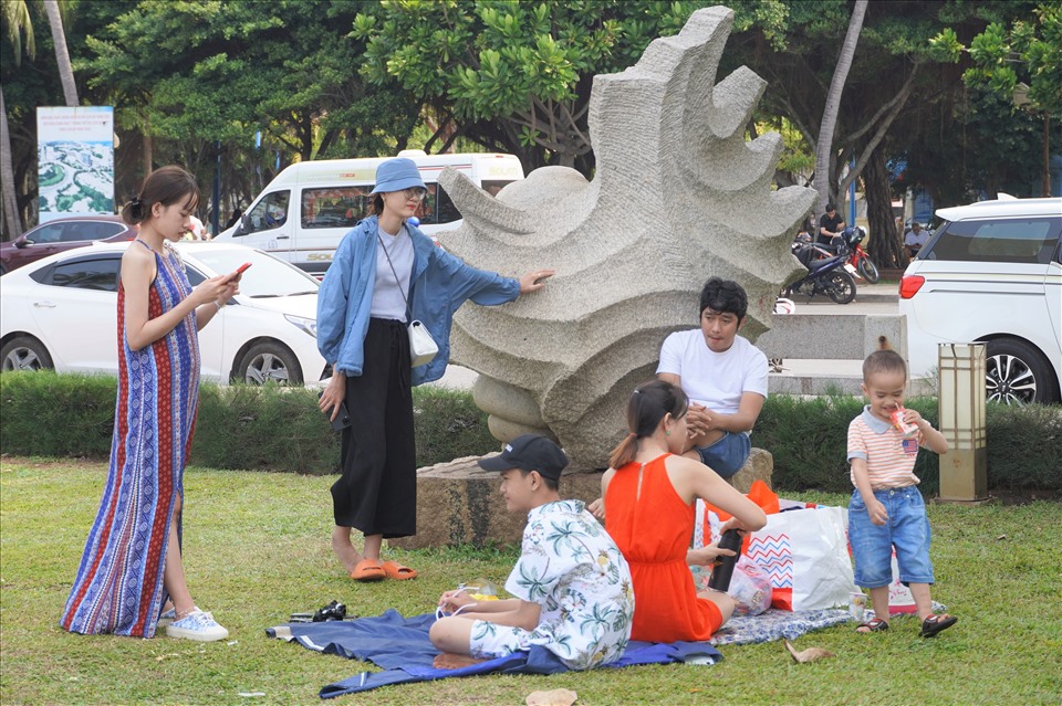 Một nhóm du khách đến từ Đồng Nai đã trải bạt nghỉ ngơi trên bãi cỏ, dưới bóng mát trong công viên. Anh Cường (một người trong nhóm) cho biết, do thấy bãi tắm êm, có công viên mát mẻ nên đã ghé vào. Nhóm khá thích thú với không khí thoáng đãng cũng như khung cảnh nơi này. Ảnh: T.A