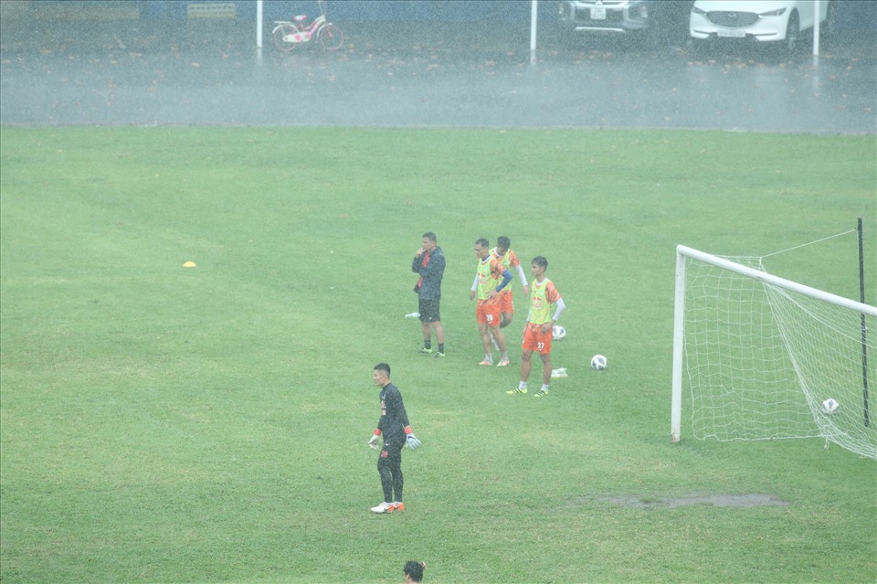 Bên ngoài sân, huấn luyện viên Kiatisak chăm chú theo dõi từng động tác của các học trò dưới cơn mưa nặng hạt.