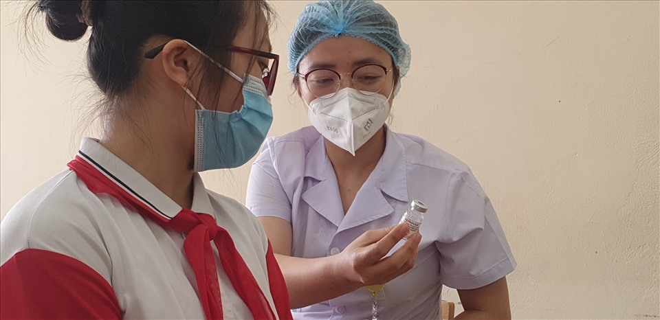 Nhân viên y tế giới thiệu về loại vaccine cho học sinh trước khi tiêm. Ảnh: Nguyễn Hùng